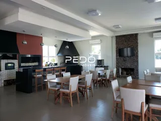 Interior de uma sala de estar com cozinha e área de jantar em um imóvel.