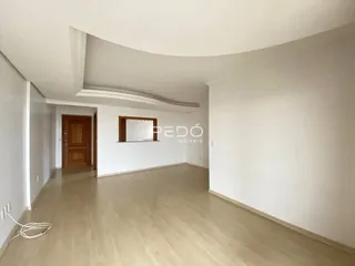 Sala de estar com piso de madeira clara e paredes brancas.
