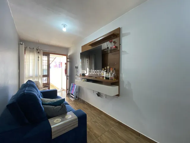 Sala de estar com sofá azul e piso de madeira.