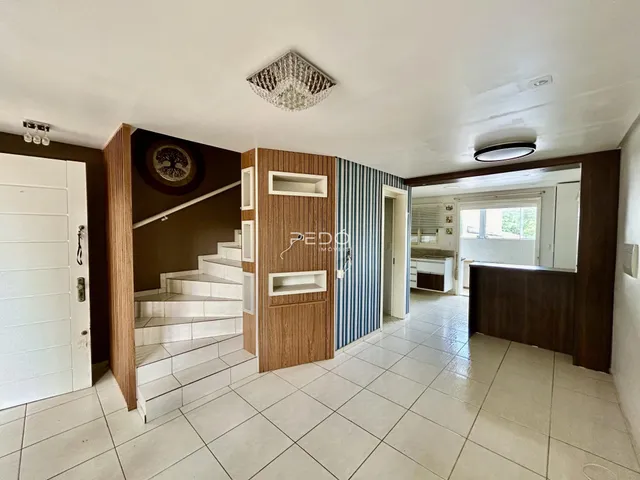 Interior de uma área comum com escadaria e piso de cerâmica.
