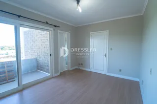 A sala apresenta piso de madeira clara e uma porta de vidro que dá acesso a uma área externa.