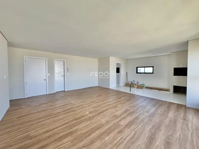 Foto de uma sala de estar ampla com piso de madeira clara.