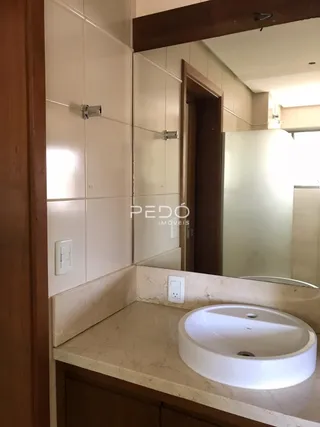 Foto de um banheiro com bancada e espelho.