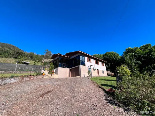 Foto da fachada de uma residência em Lajeado, com paisagem verde ao fundo.