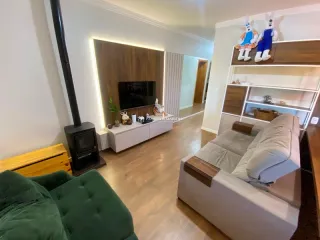 Sala de estar com sofá e painel de madeira na residência.