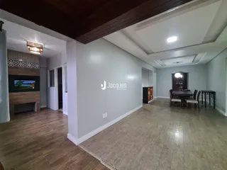 Ambiente interno de uma sala de estar com piso de madeira e lareira.