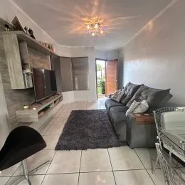 Foto interna de uma sala com painéis de madeira e piso claro.