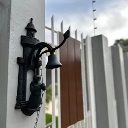 Detalhe de um acessório externo montado na parede branca.