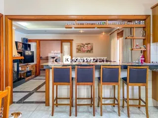 Ambiente interno com mesa de jantar e detalhes em madeira.
