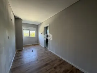 Hall de entrada com piso de madeira clara e paredes cinzas.
