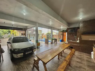 Vista interna de uma sala de estar com portas de vidro que dão acesso ao exterior.