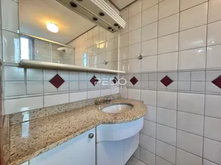 Foto de um banheiro com revestimento de cerâmica branca e bancada de granito.