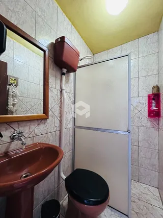 Foto de um banheiro com pia e vaso sanitário em cerâmica.