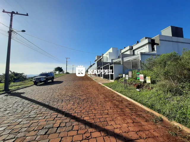 Foto da fachada de um conjunto de casas modernas em Lajeado, Brasil, sob céu azul.