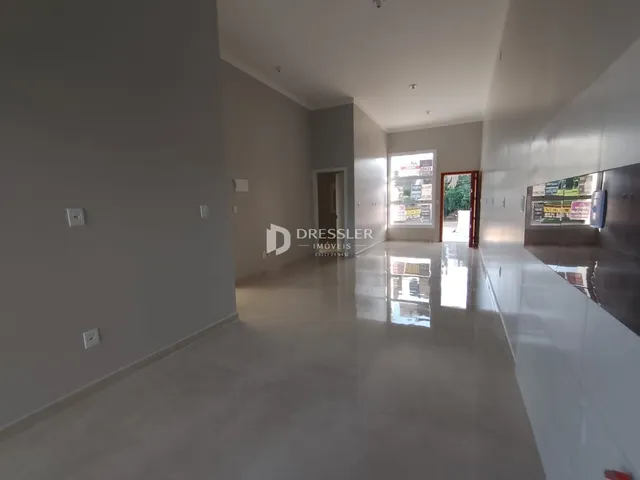 Corredor interno de uma residência com piso reflexivo e paredes claras.