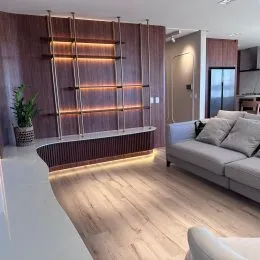 Sala de estar com painéis de madeira e piso claro.
