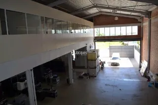 Espaço interno amplo com teto alto e estrutura de concreto.