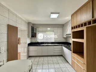 Cozinha com armários brancos e piso de cerâmica.