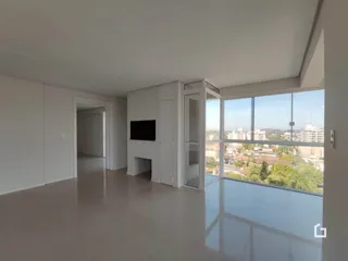 Interior de uma sala com piso claro e grande janela.