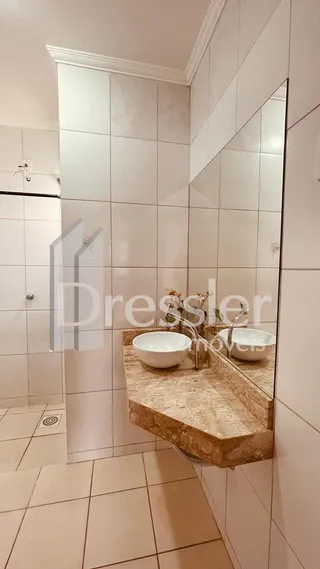 Interior de um banheiro com revestimento cerâmico e espelho.
