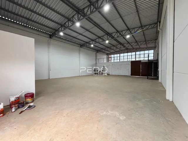 Espaço interno amplo com teto de estrutura metálica.