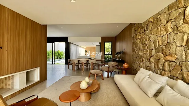 Ambiente de sala de estar e jantar com paredes de pedra e painéis de madeira.