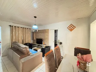Sala de estar com sofá e televisão em ambiente claro.
