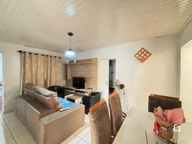 Sala de estar com sofá e televisão em ambiente claro.