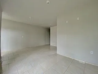 Ambiente interno amplo com piso de cerâmica e paredes brancas.