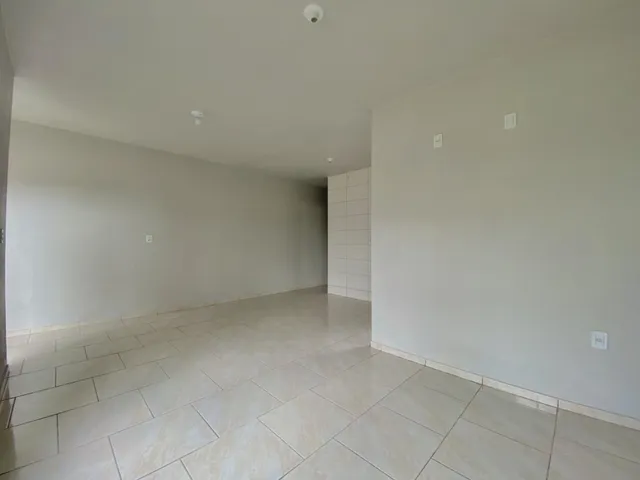 Ambiente interno amplo com piso de cerâmica e paredes brancas.