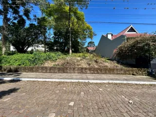 Fachada de uma casa em Lajeado, Brasil, com vegetação ao fundo.