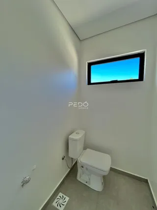 Foto de um banheiro com piso de cerâmica e janela.