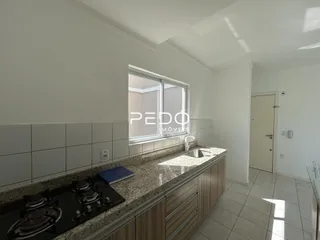 Vista da cozinha com bancada e armários em uma residência.