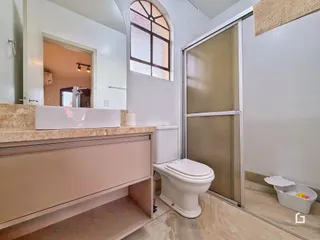 Foto interna de um banheiro com bancada e vaso sanitário.