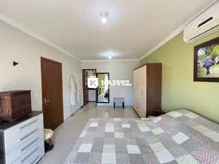 Foto interna de um quarto com cama e armário em um imóvel.