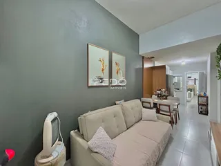 Sala de estar com sofá e parede cinza em um imóvel no Brasil.
