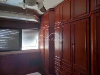 Armários de madeira escura e painéis decorativos são visíveis no interior da sala.