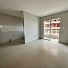 Vista interna de um ambiente amplo com piso claro e paredes neutras.