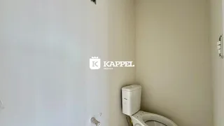 Foto de um banheiro com um vaso sanitário branco.