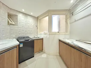 Cozinha com armários de madeira e bancadas de mármore.
