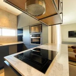 Foto de um balcão de cozinha com bancada de mármore e cooktop preto.