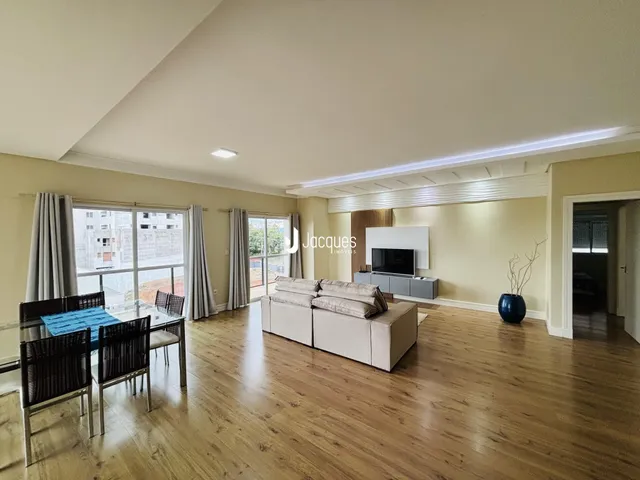 Sala de estar com piso de madeira e grandes janelas em Lajeado, Brasil.