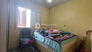 Quarto com cama e cadeira de vime em uma sala de Lajeado.