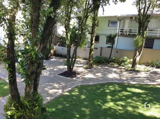 Área externa com árvores e gramado no imóvel.