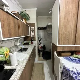 Foto de uma cozinha com armários de madeira e bancadas claras.
