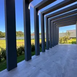 Vista de um corredor coberto com colunas em um imóvel em Lajeado.