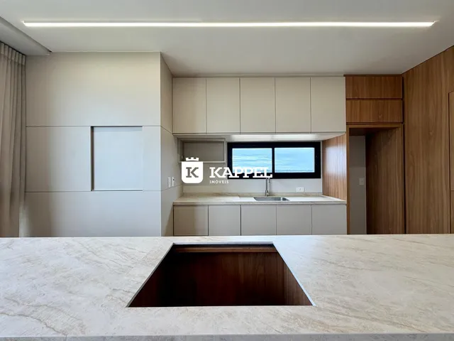 Cozinha moderna com armários claros e bancada de granito.