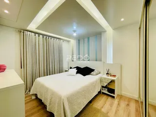 Quarto com cama e janela em ambiente claro.