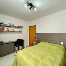 Quarto com cama e prateleiras na parede em um imóvel.