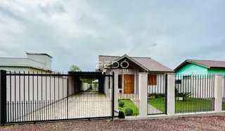 Fachada de uma residência com cerca e portão de ferro preta em Lajeado.